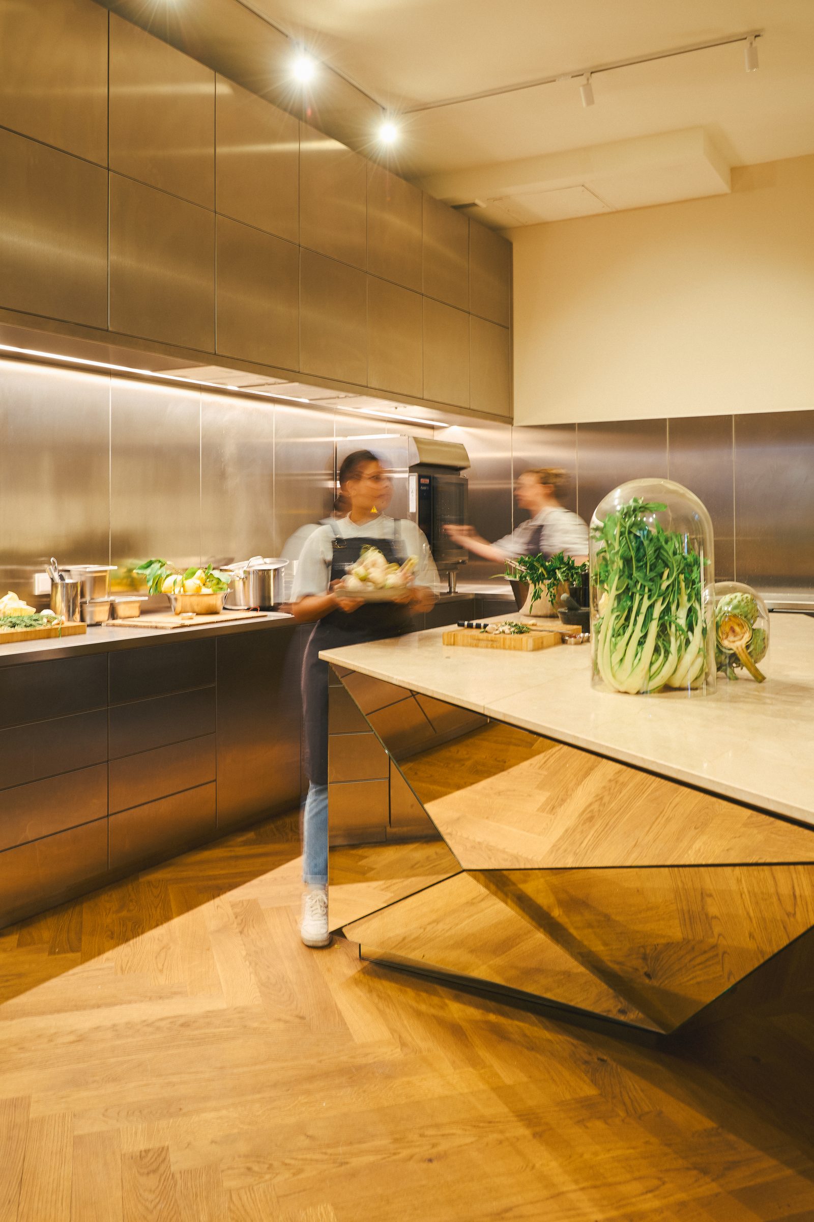 Two cooks at work around the marble kitchen island