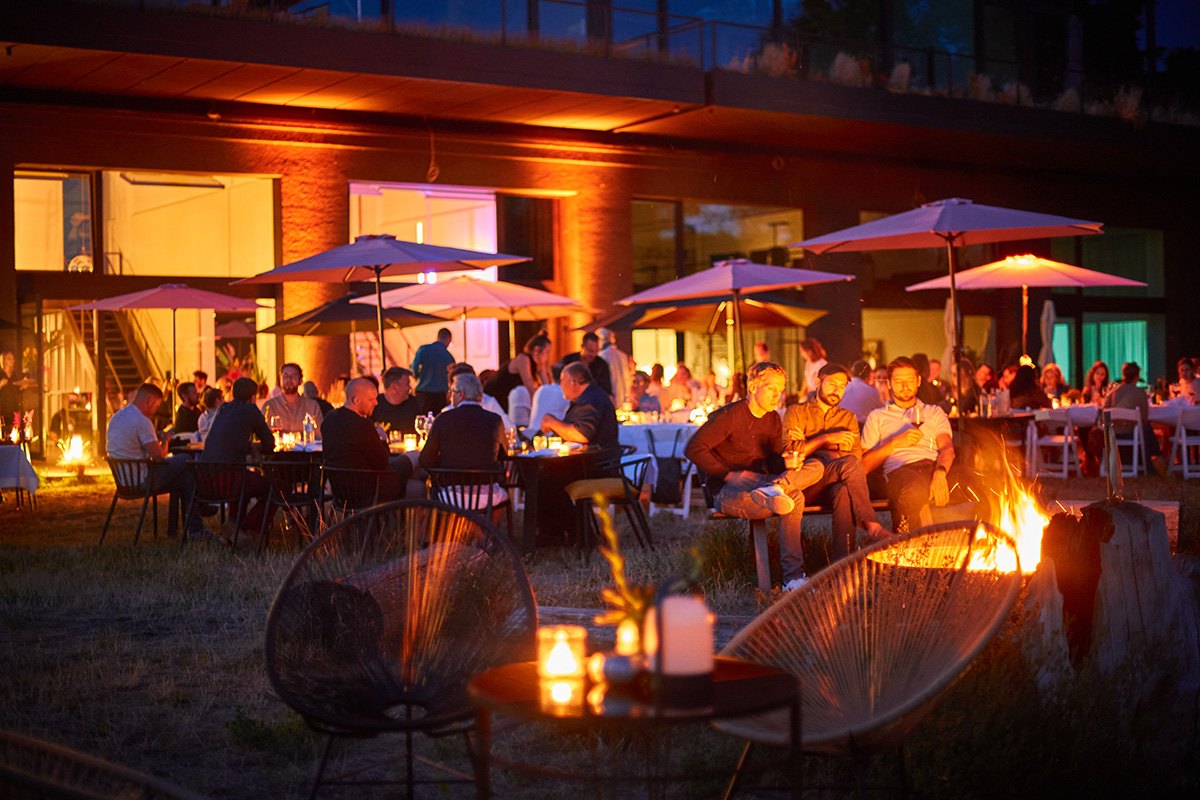 Guests outside at Studio LA FLOR in the evening, around a fire