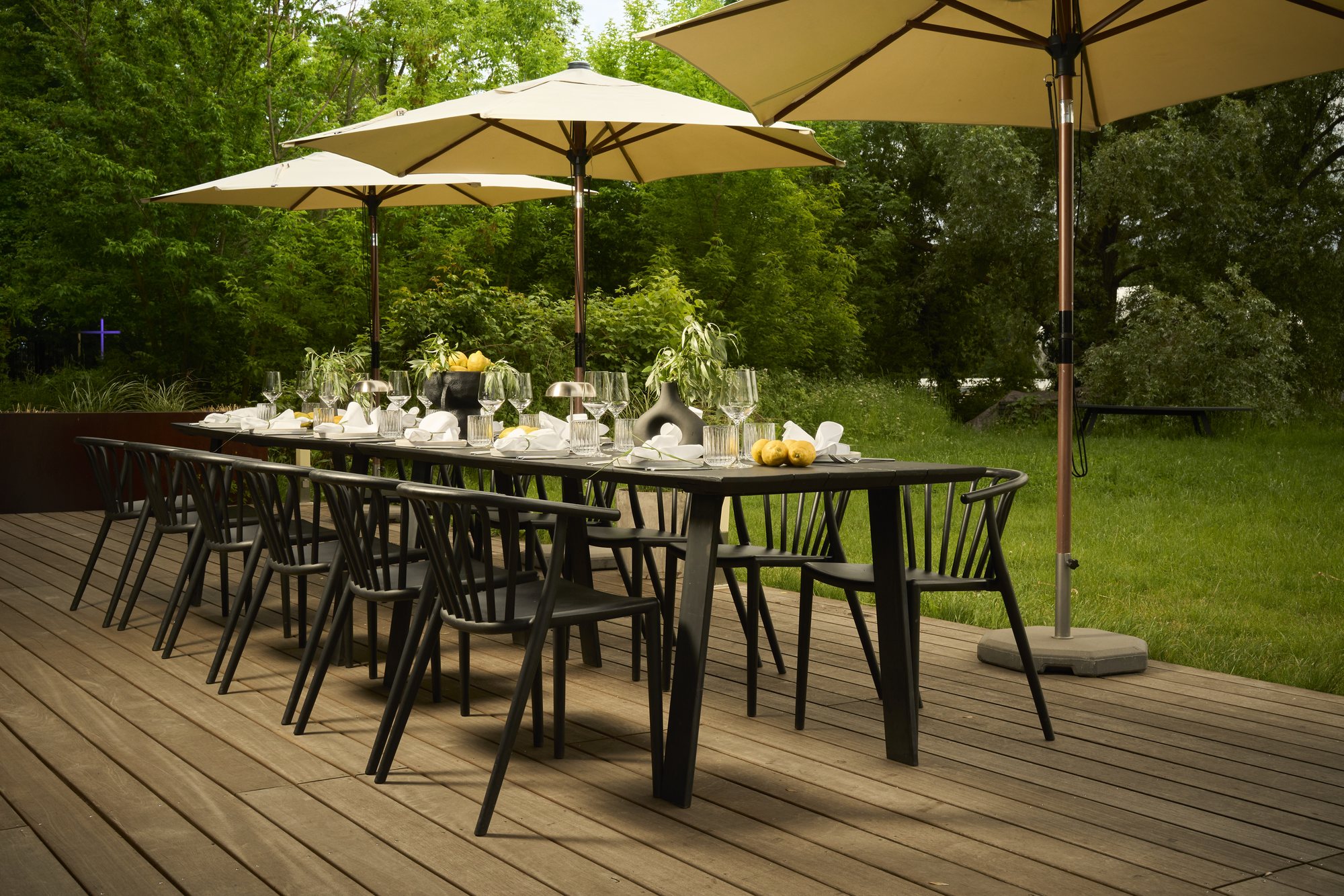 A long black table set for dinner on the terrace at Studio LA FLOR